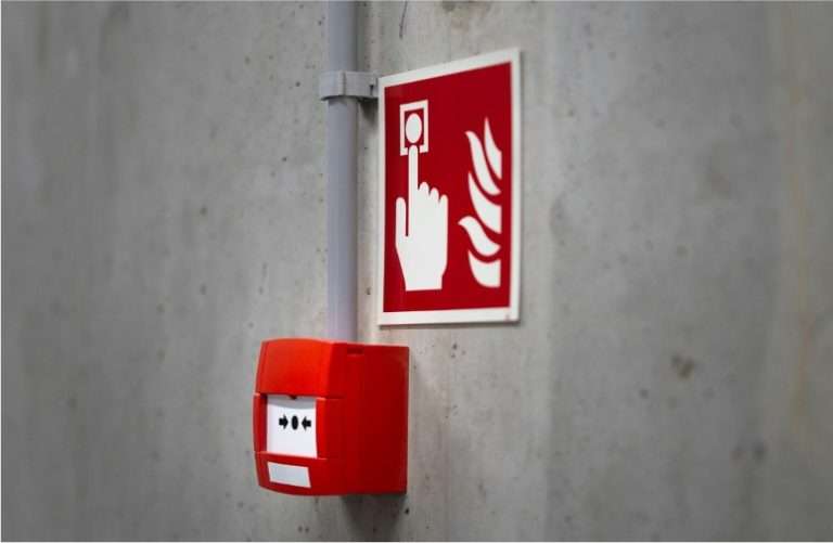 Fire safety consultant viewing manual call point and signage